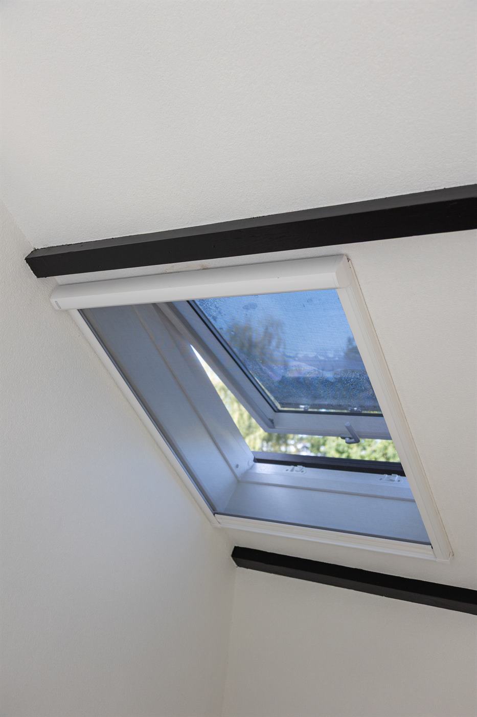 Zolderkamer met dakraam waar een airco is geplaatst