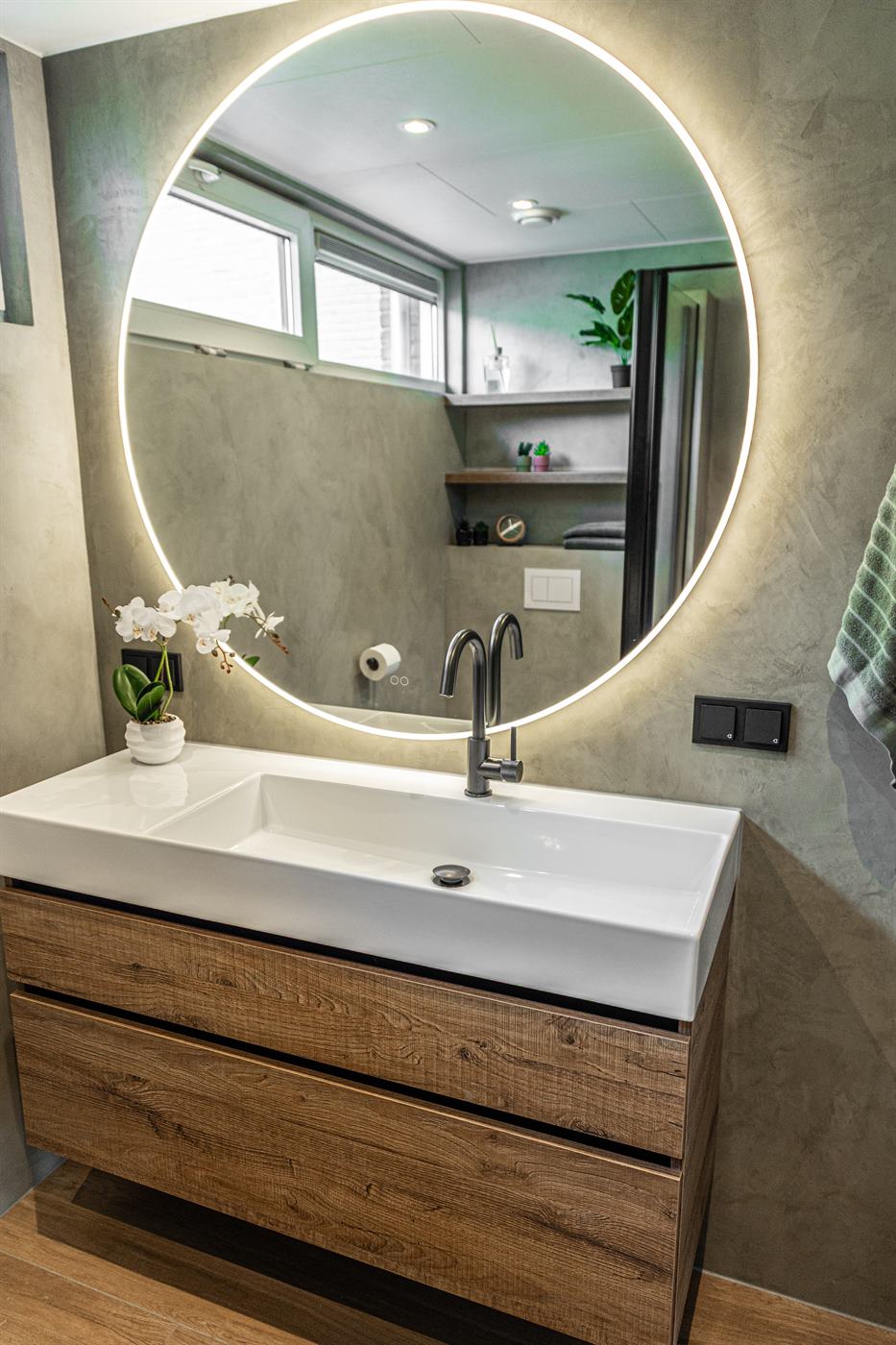 Overzicht van een complete badkamer met douche en wastafel