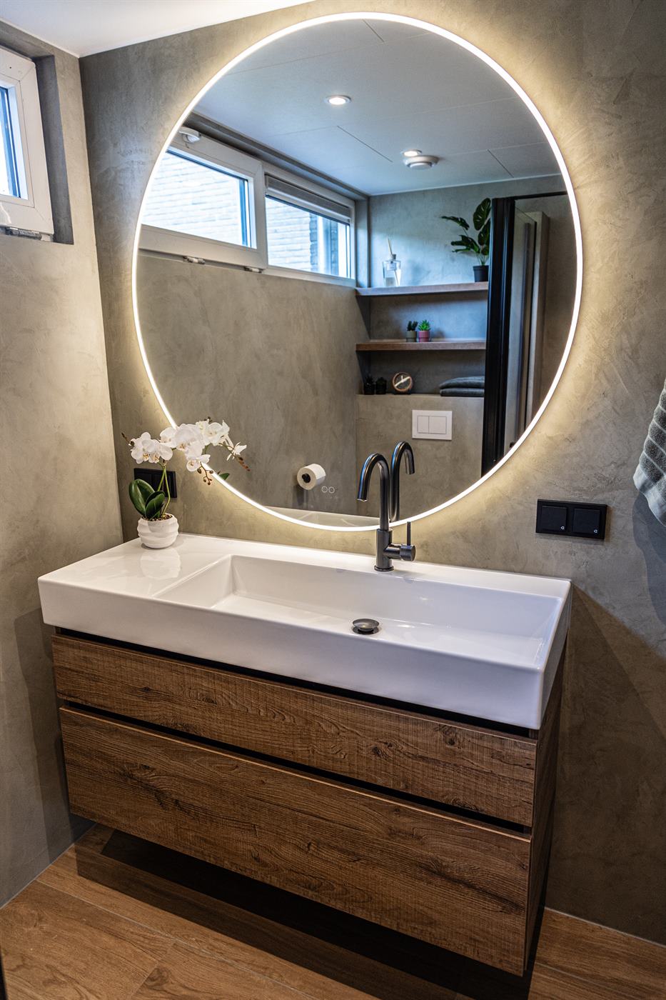 Badkamer met ronde spiegel opgeleverd door Hoving Assen